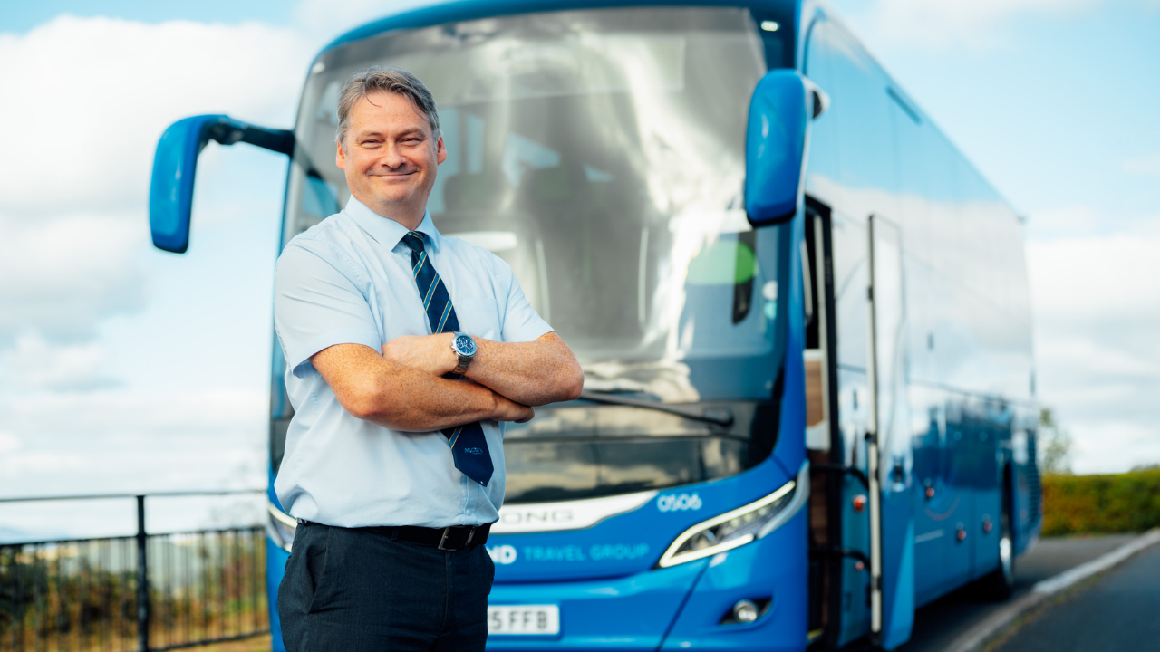 Coach driver standing in front of coach